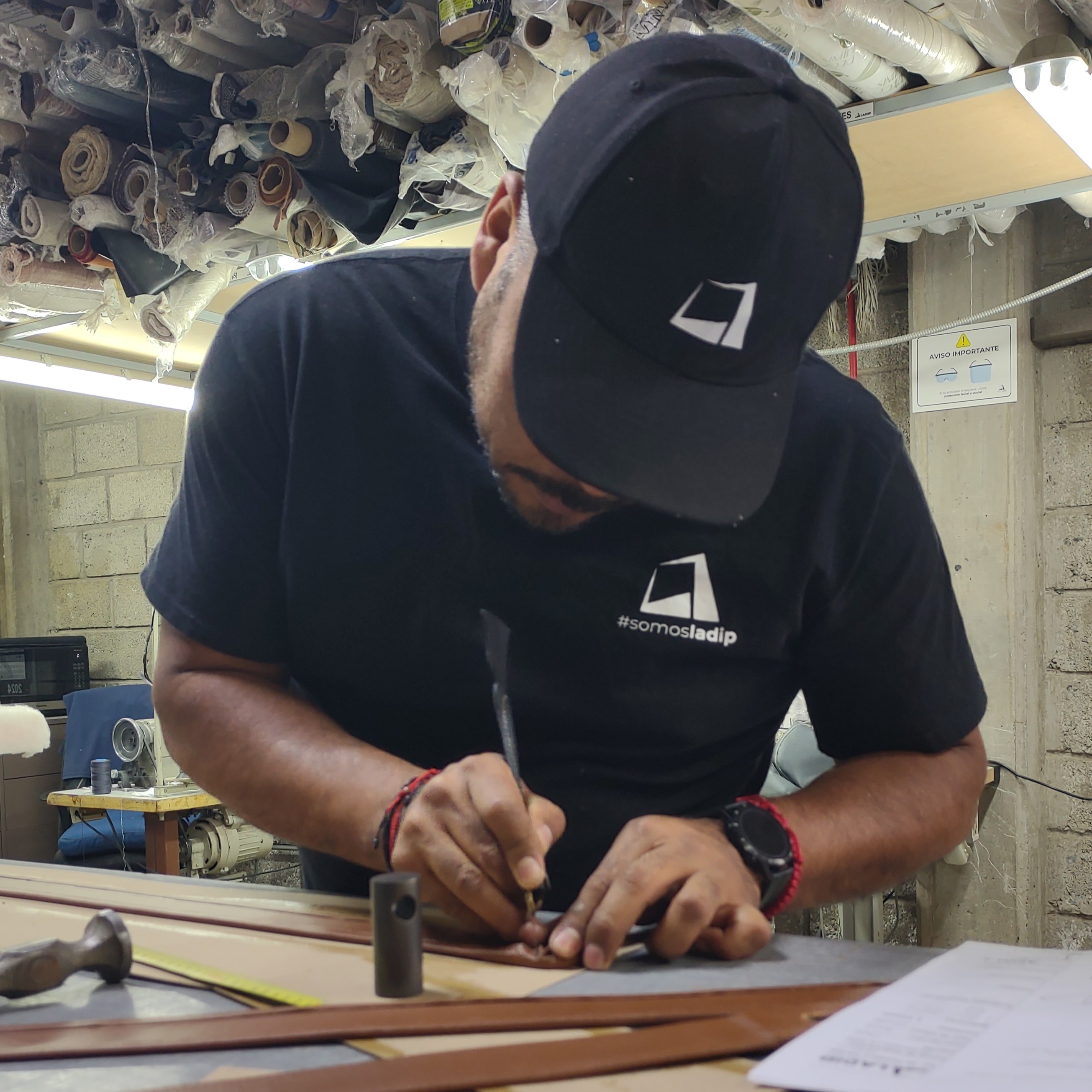Un hombre de mediana edad tejiendo tiras de piel